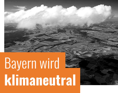 Das Bild zeigt eine Luftaufnahme einer Landscht; Das Bild trägt die Aufschrift Bayern wird klimaneutral